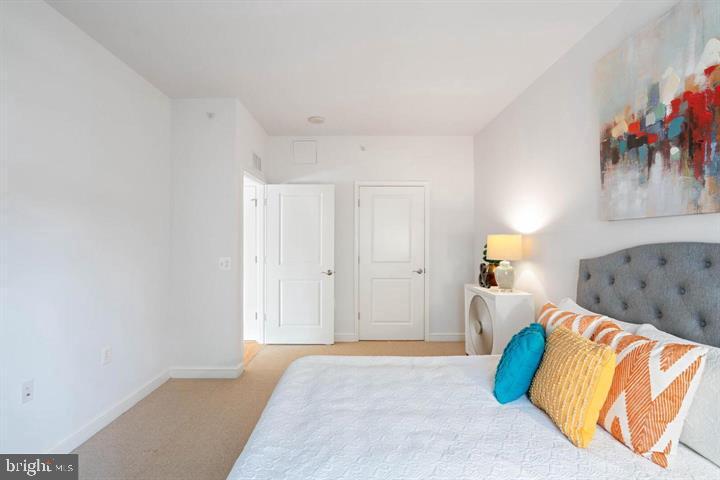 11990 Market Street, Unit 1311 Reston, VA 20190 - Photo 49 of 59 a spacious bedroom with a bed and a couch