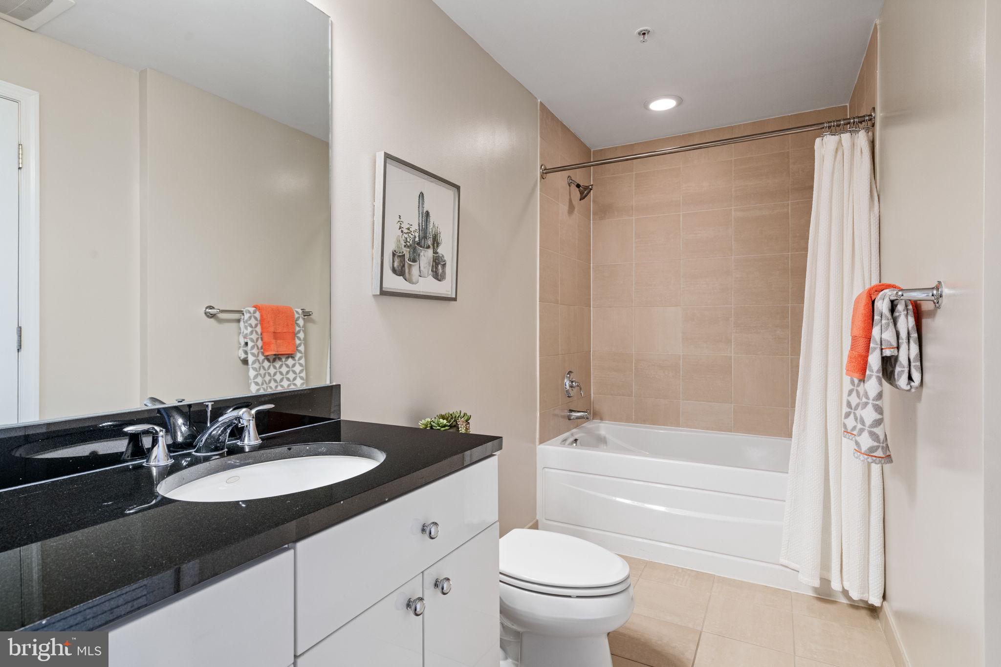 11990 Market Street, Unit 1311 Reston, VA 20190 - Photo 52 of 59 a bathroom with a granite countertop sink toilet and shower