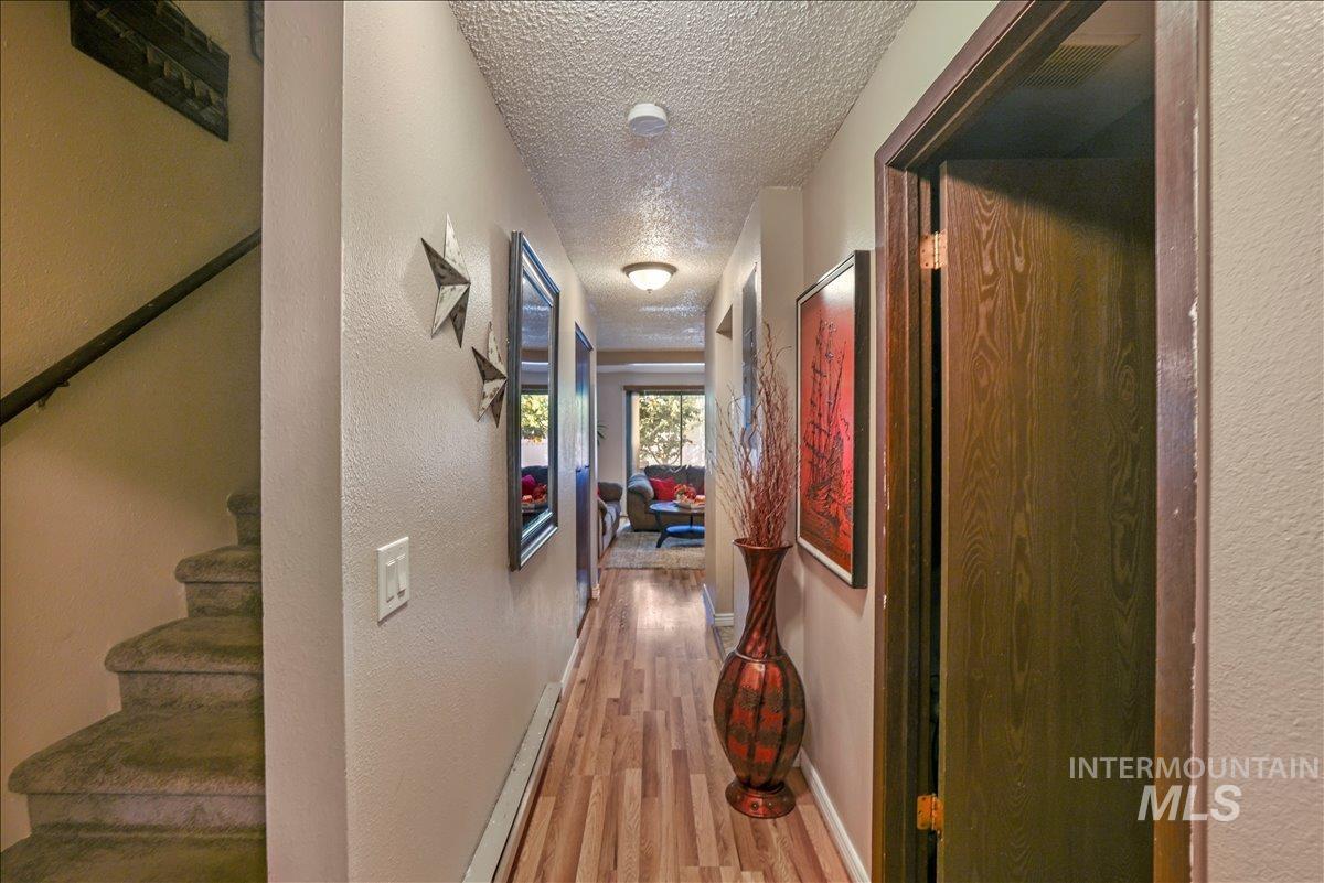 259 Pheasant Road West, Unit 2 Twin Falls, ID 83301 - Photo 13 of 31 Corridor featuring a textured ceiling, a textured wall, and light wood finished floors