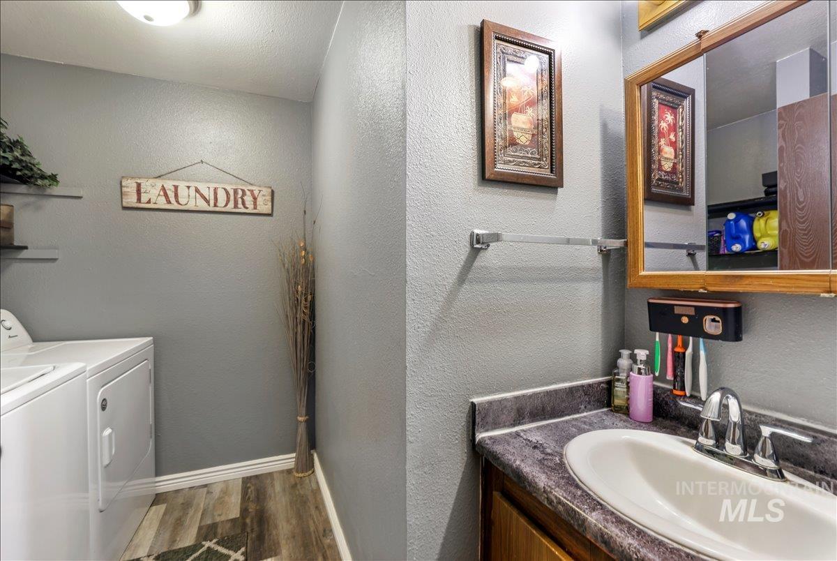 259 Pheasant Road West, Unit 2 Twin Falls, ID 83301 - Photo 16 of 31 Bathroom with a textured wall, dark wood-style flooring, vanity, and washer and clothes dryer