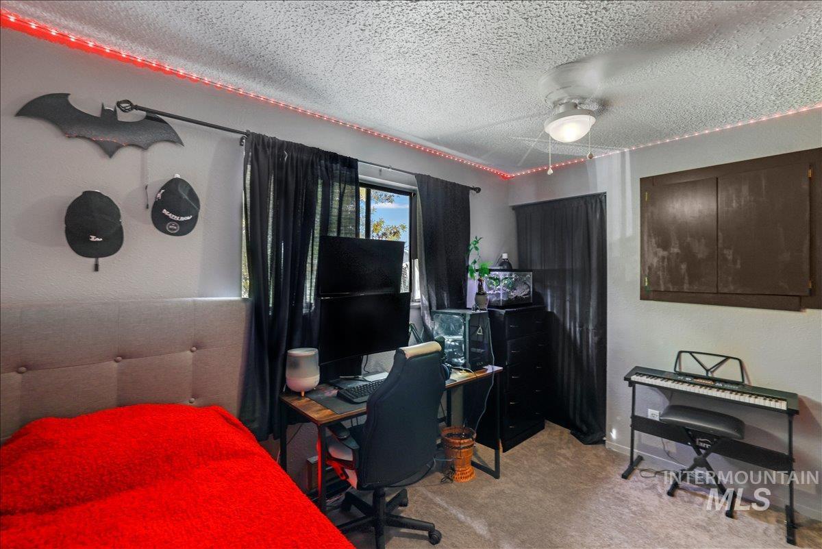 259 Pheasant Road West, Unit 2 Twin Falls, ID 83301 - Photo 19 of 31 Bedroom featuring a textured ceiling, light colored carpet, an office area, and ceiling fan