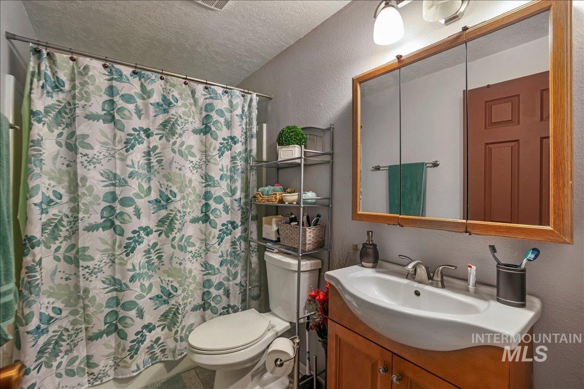 259 Pheasant Road West, Unit 2 Twin Falls, ID 83301 - Photo 20 of 31 Bathroom featuring a textured wall, a textured ceiling, vanity, and a shower with shower curtain