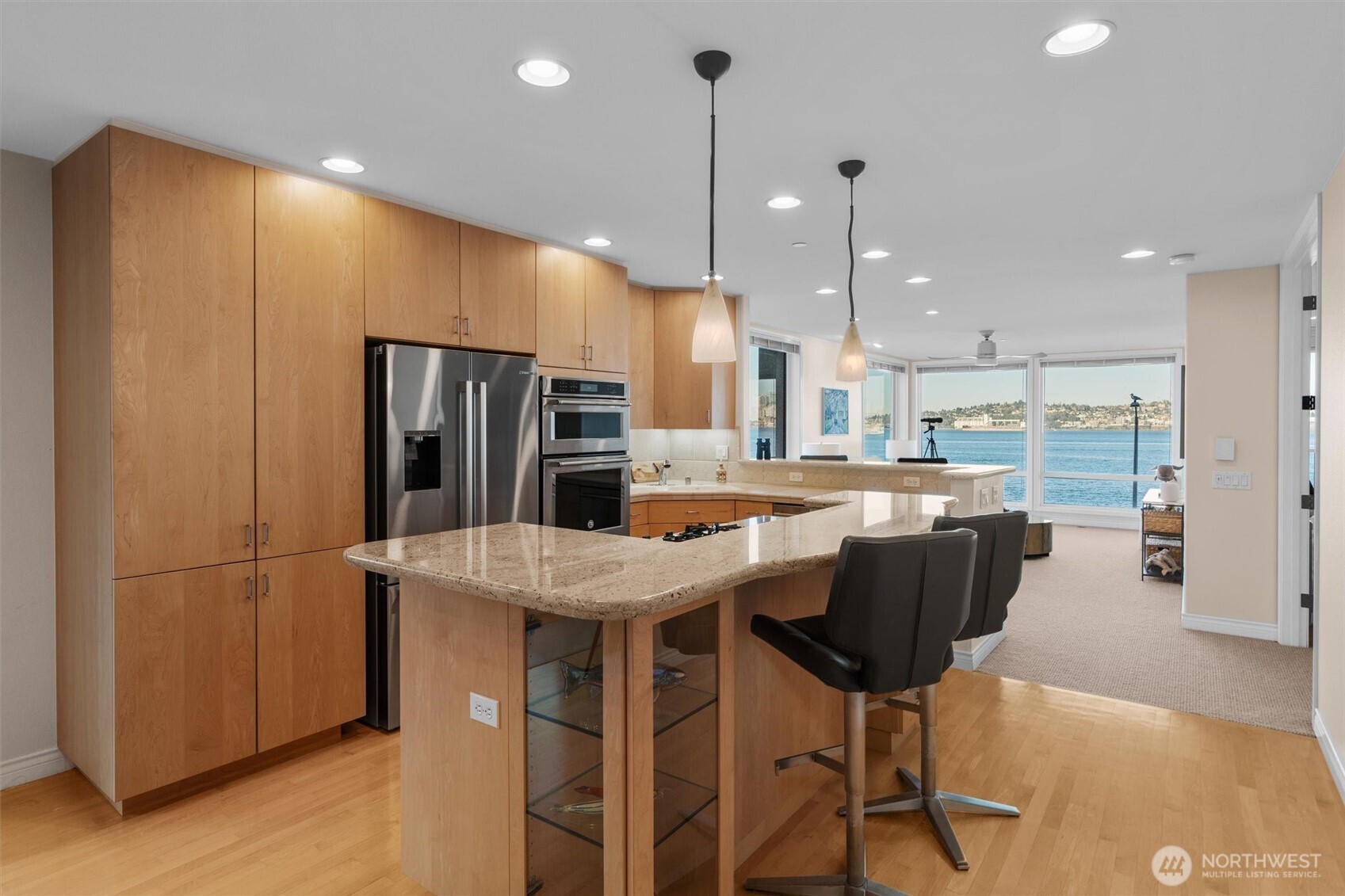 1005 Harbor Avenue Southwest, Unit 400 Seattle, WA 98116 - Photo 8 of 39 a kitchen with stainless steel appliances kitchen island granite countertop a refrigerator a stove a kitchen island with a dining table and chairs