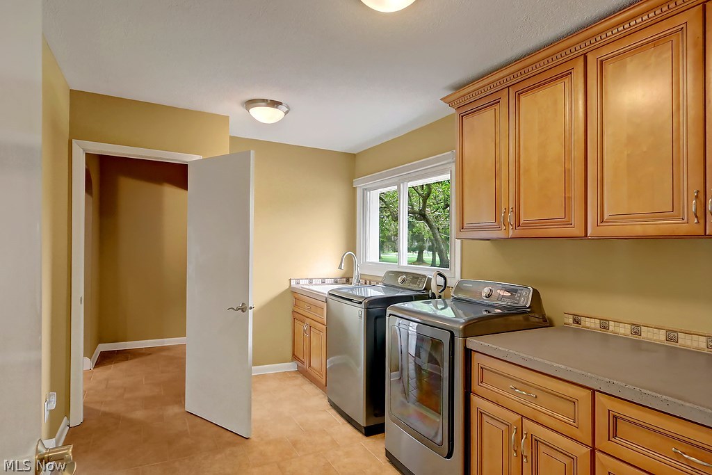 2632 Brainard Road Cleveland, OH 44124 - Photo 12 of 25 The laundry room is located near the master wing. It has concrete counter tops, ceramic tile floors, a window for natural light and laundry sink, too.