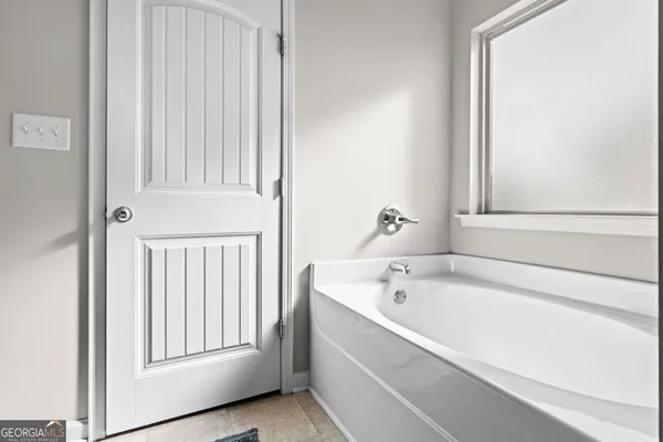 a bathroom with a bathtub and a window