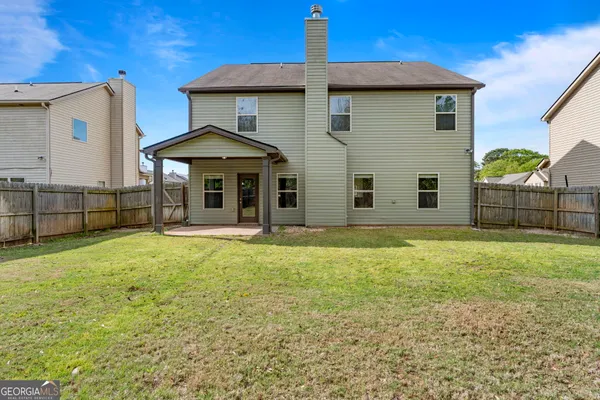 a view of a house with backyard and balcony