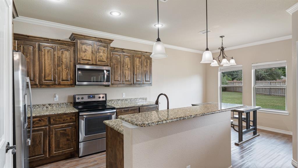 1401 Ridgebriar Drive Kaufman, TX 75142 - Photo 6 of 26 Kitchen featuring bar top and granite countertops