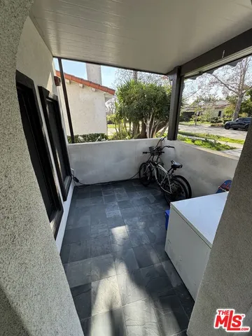 a kitchen with stainless steel appliances kitchen island granite countertop a table chairs and a refrigerator