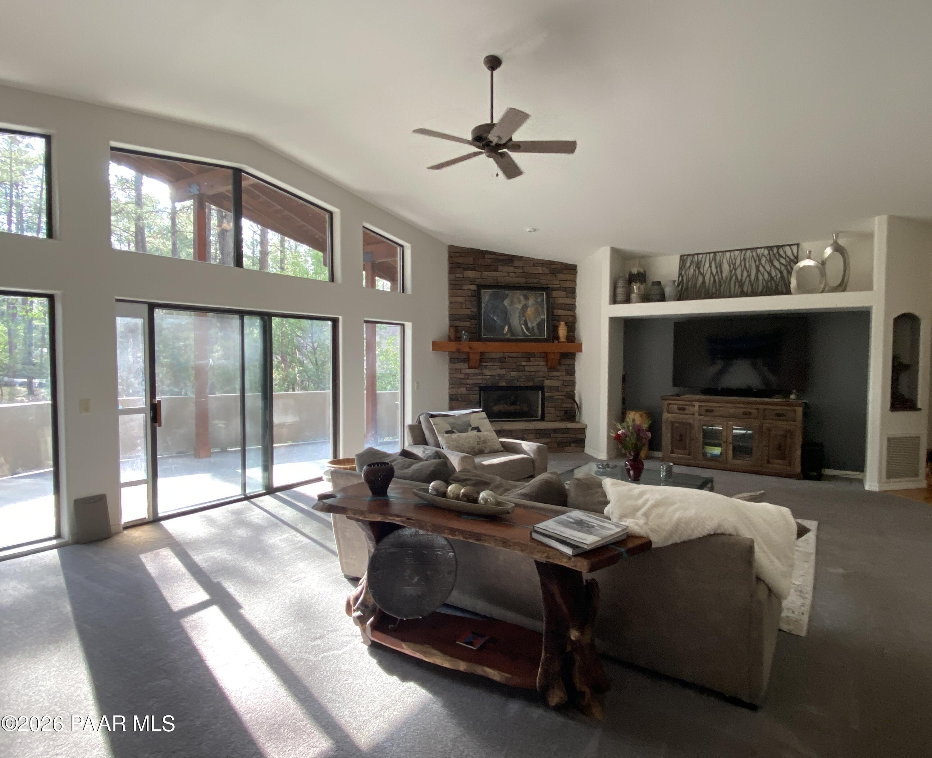 1677 Coyote Road Prescott, AZ 86303 - Photo 2 of 24 a living room with furniture a fireplace and a flat screen tv