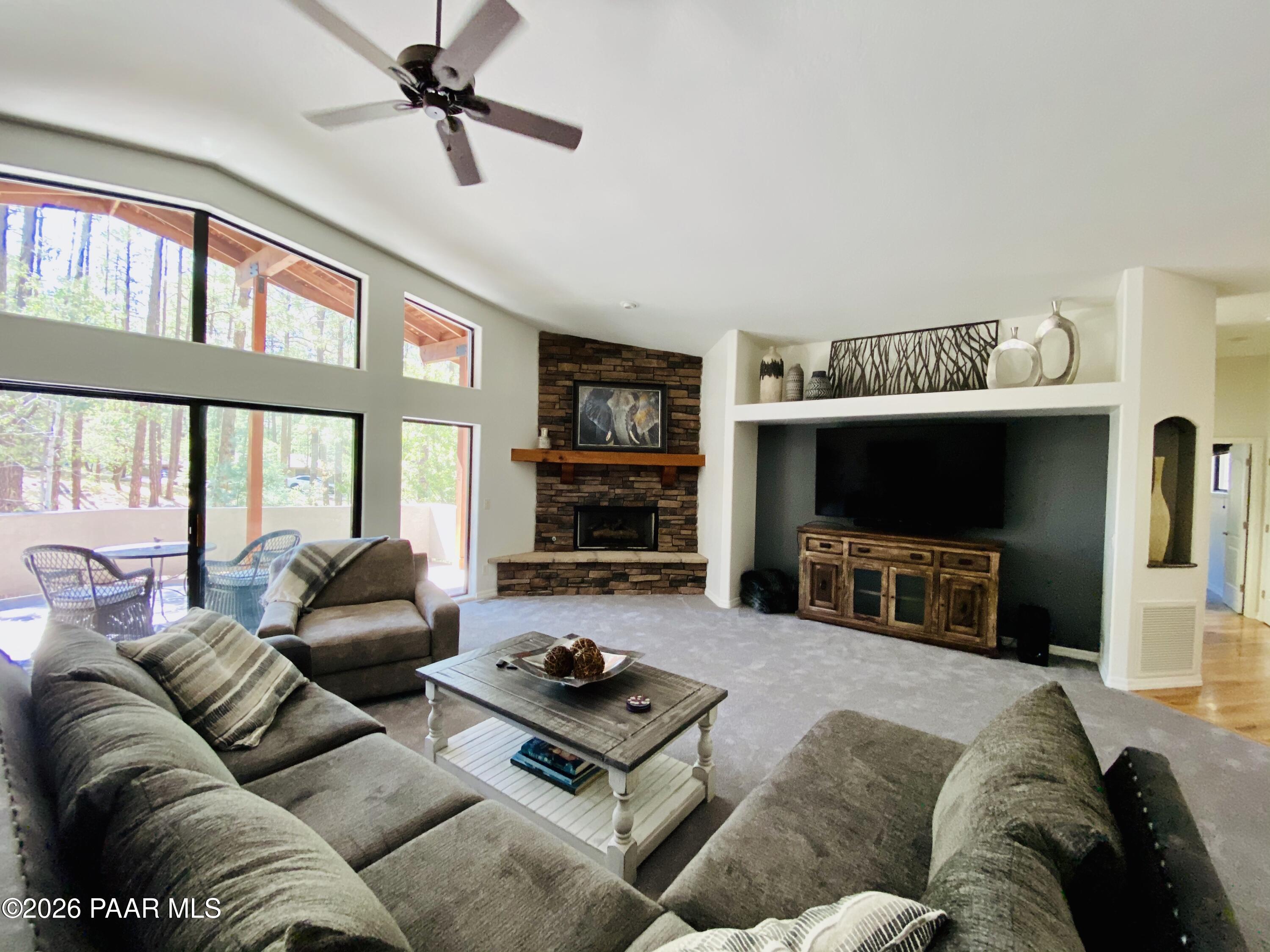 1677 Coyote Road Prescott, AZ 86303 - Photo 4 of 24 a living room with furniture a large window and a flat screen tv