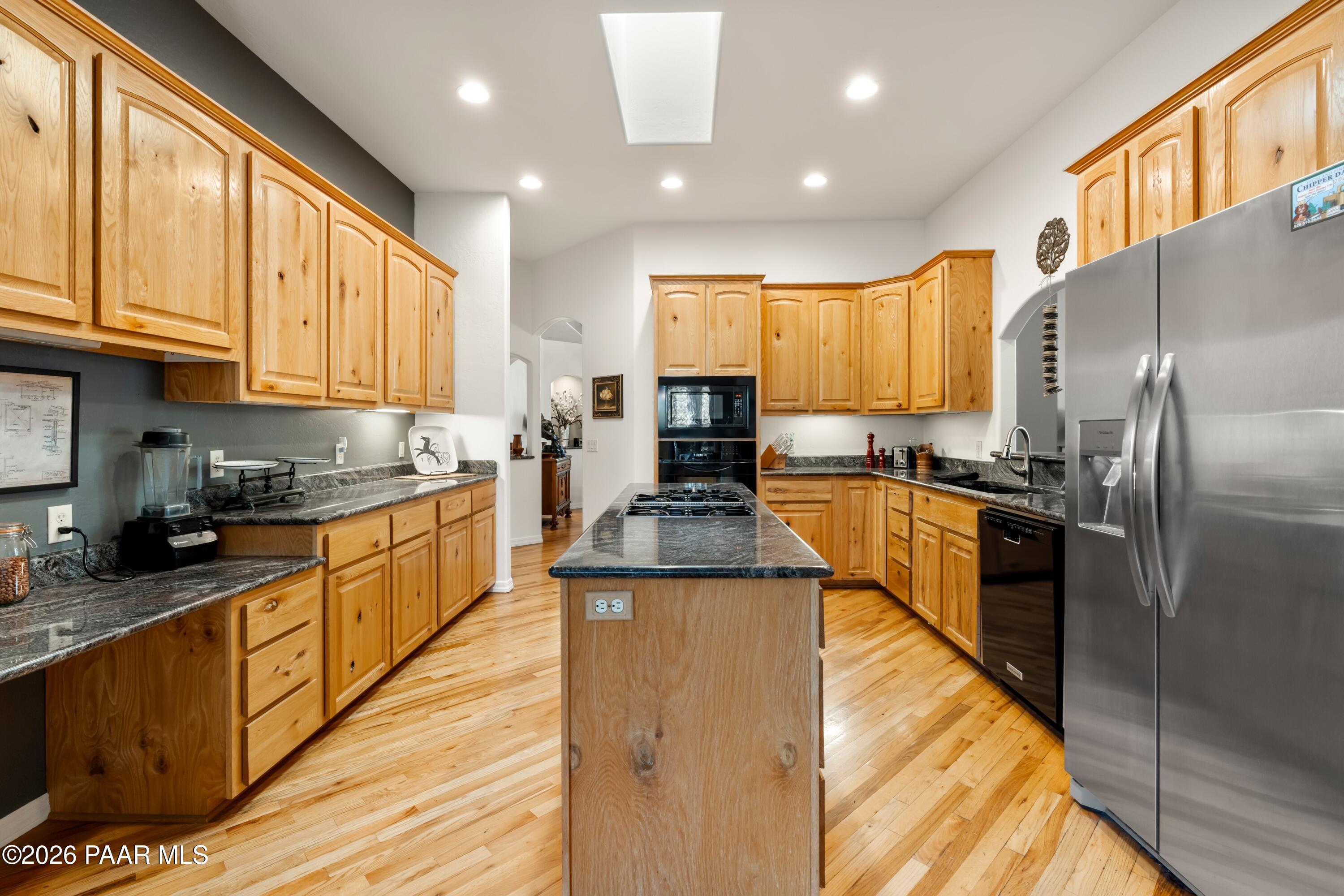 1677 Coyote Road Prescott, AZ 86303 - Photo 6 of 24 a kitchen with stainless steel appliances granite countertop a refrigerator a stove top oven a sink and dishwasher with wooden floor