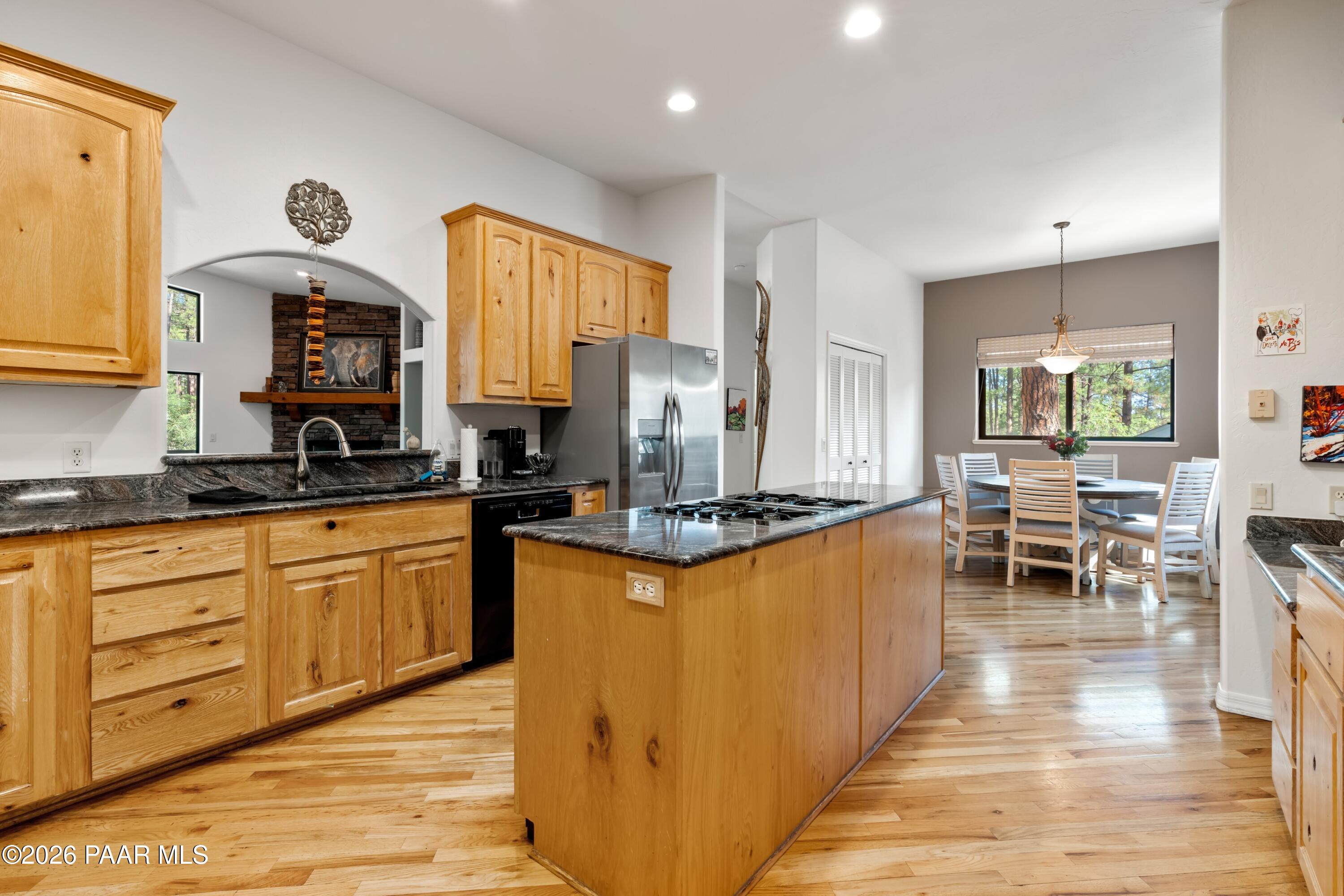 1677 Coyote Road Prescott, AZ 86303 - Photo 7 of 24 a kitchen with stainless steel appliances granite countertop a stove top oven a sink dishwasher and cabinets with wooden floor