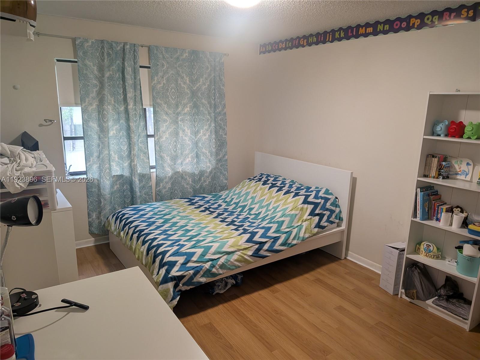 8540 Southwest 149th Avenue, Unit 815 Miami, FL 33193 - Photo 11 of 16 a bedroom with a bed and book shelf