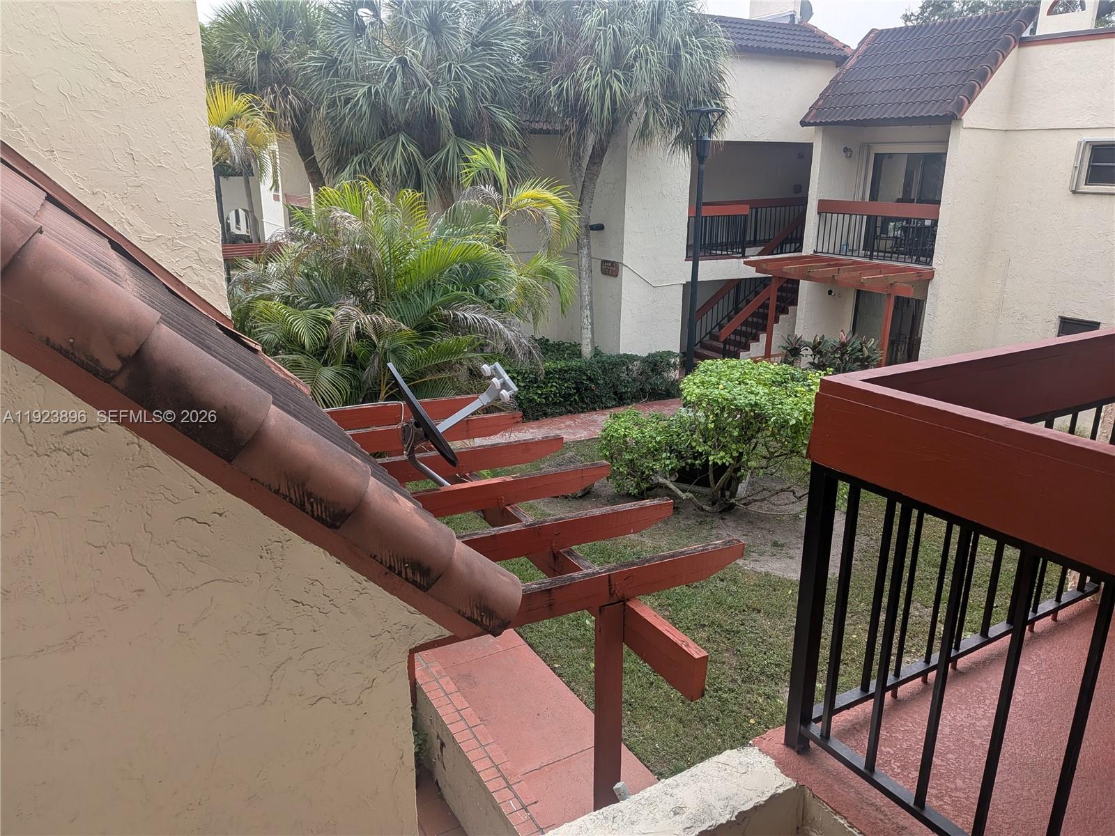 8540 Southwest 149th Avenue, Unit 815 Miami, FL 33193 - Photo 16 of 16 a view of a patio with table and chairs with wooden fence and plants