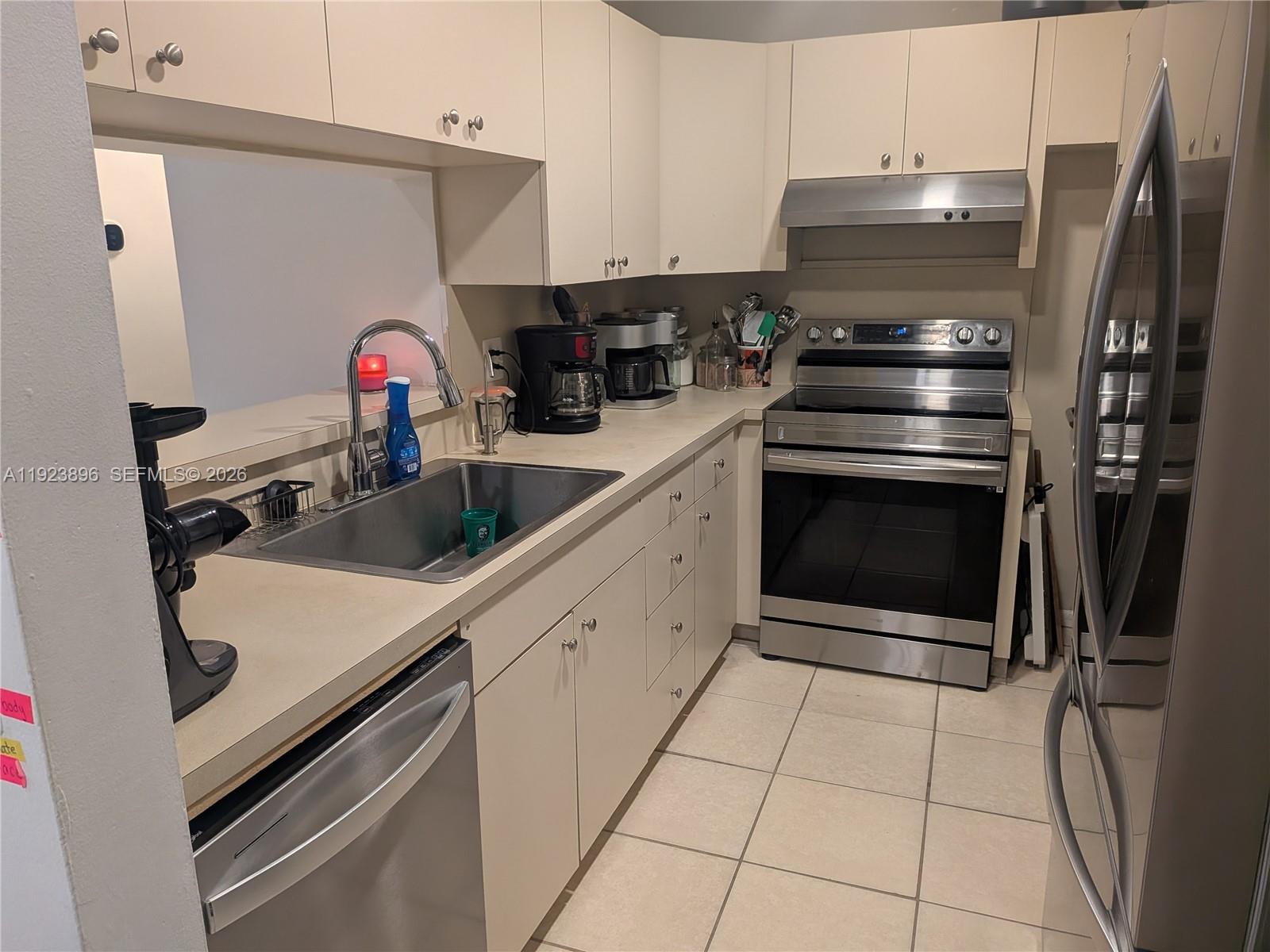 8540 Southwest 149th Avenue, Unit 815 Miami, FL 33193 - Photo 3 of 16 a kitchen with a sink and a stove top oven