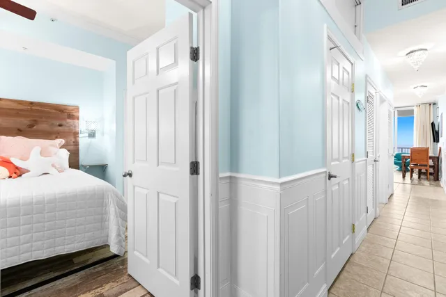 a bedroom with a bed a table and a large mirror