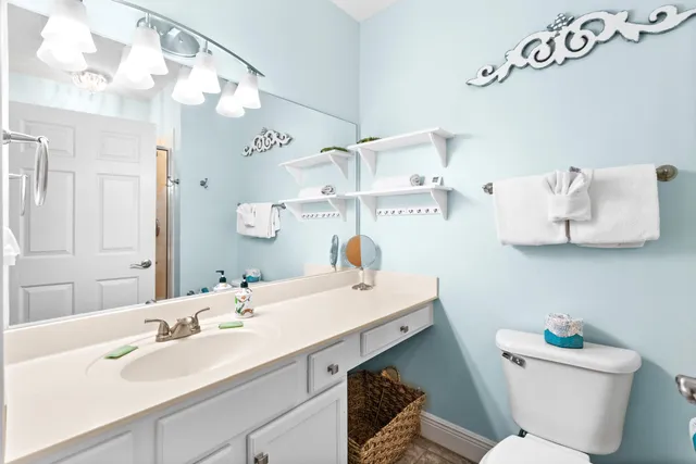 a bathroom with a sink vanity mirror and toilet