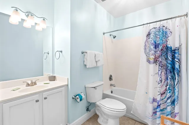 a bathroom with a sink a toilet and shower curtain