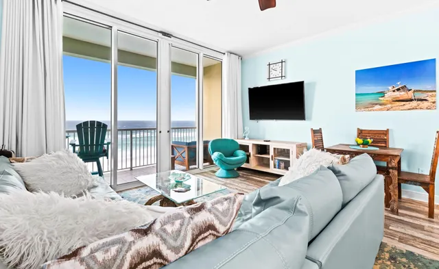 a living room with furniture a flat screen tv and a large window