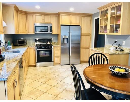 22 Azalea Road Sharon, MA 02067 - Photo 6 of 27 a kitchen with stainless steel appliances kitchen island a table chairs and a refrigerator
