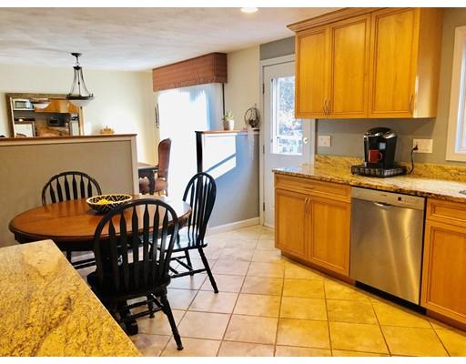 22 Azalea Road Sharon, MA 02067 - Photo 9 of 27 a kitchen with stainless steel appliances granite countertop a sink a stove a dining table and chairs with wooden floor