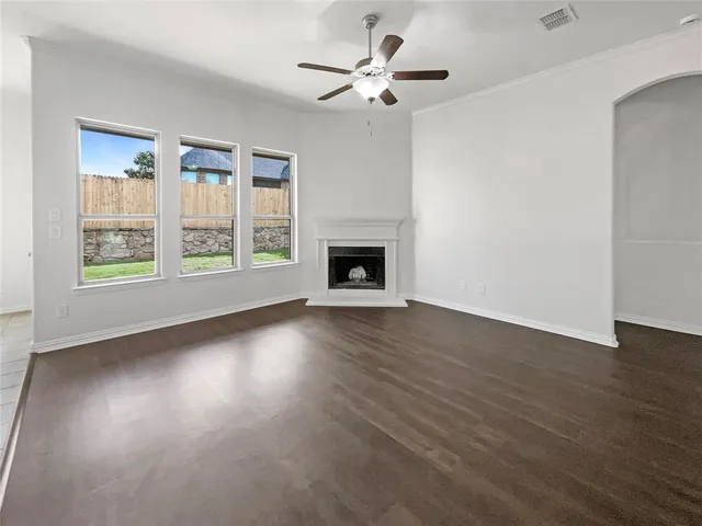 a view of wooden floor fire place chandelier and windows in a room
