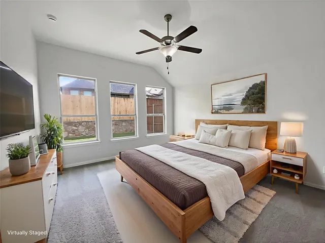 a spacious bedroom with a bed and a large window