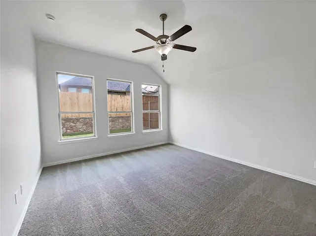 an empty room with windows and ceiling fan