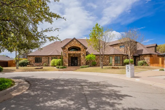 a front view of a house with a yard and potted plants