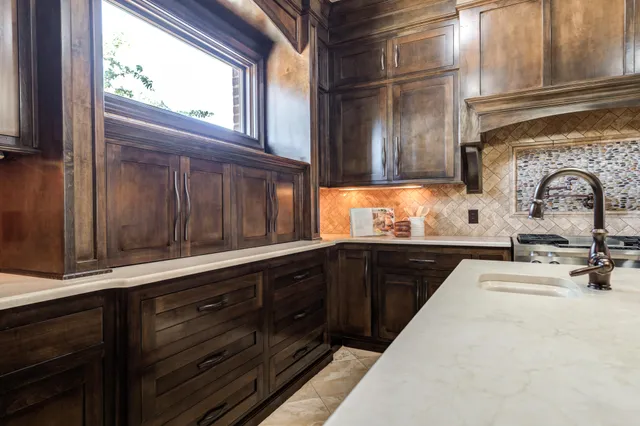 a spacious bedroom with a bed a dresser and wooden floor