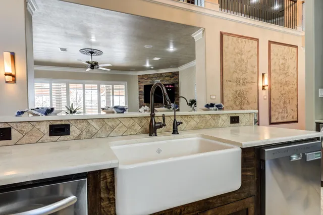 an empty room with wooden floor a ceiling fan a fireplace and windows