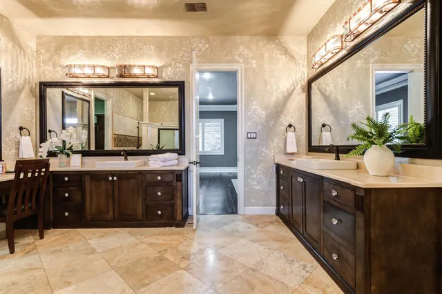 a bathroom with a granite countertop toilet sink and mirror