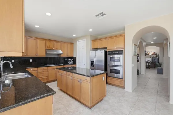 a kitchen with stainless steel appliances granite countertop a refrigerator and a sink