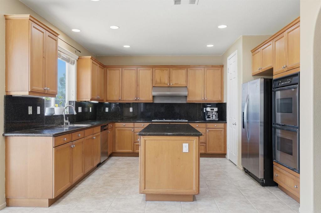 2784 Rambling Vista Road Chula Vista, CA 91915 - Photo 14 of 42 a kitchen with stainless steel appliances granite countertop a stove a sink and a refrigerator