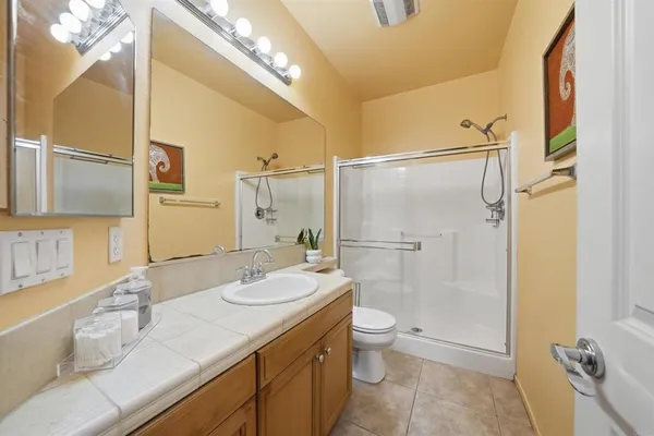a bathroom with a granite countertop sink toilet and shower
