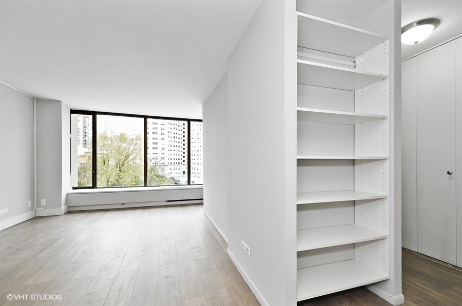 5455 North Sheridan Road, Unit 509 Chicago, IL 60640 - Photo 3 of 19 a view of an empty room with a window and wooden floor