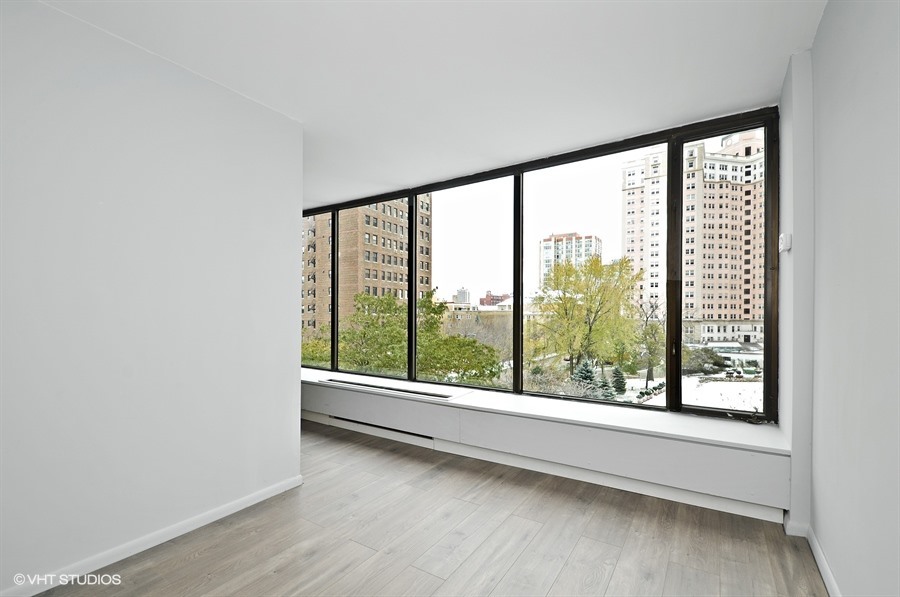 5455 North Sheridan Road, Unit 509 Chicago, IL 60640 - Photo 4 of 19 an empty room with wooden floor and windows