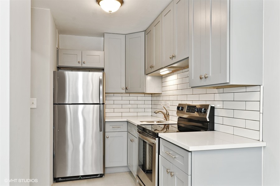 5455 North Sheridan Road, Unit 509 Chicago, IL 60640 - Photo 6 of 19 a kitchen with a refrigerator stove and cabinets