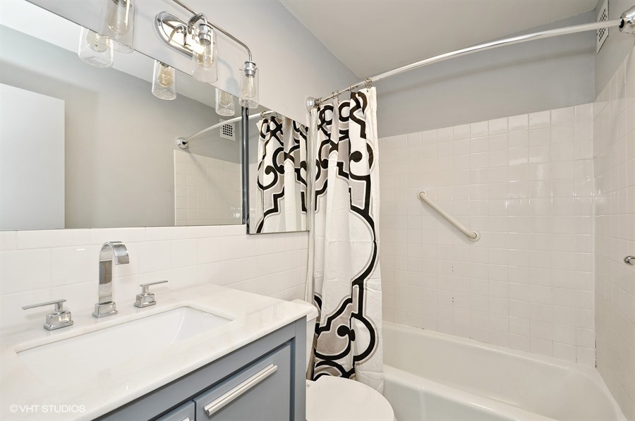 5455 North Sheridan Road, Unit 509 Chicago, IL 60640 - Photo 8 of 19 a bathroom with a sink a mirror and a shower