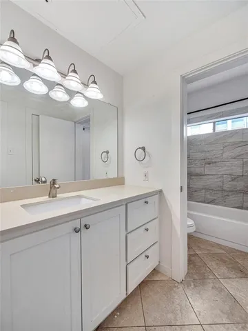 a bathroom with a double vanity sink mirror and bathtub