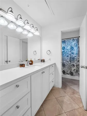 a spacious bathroom with a double vanity sink a mirror and a shower