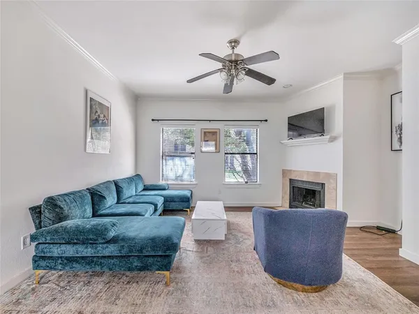 a living room with furniture a flat screen tv and a fireplace