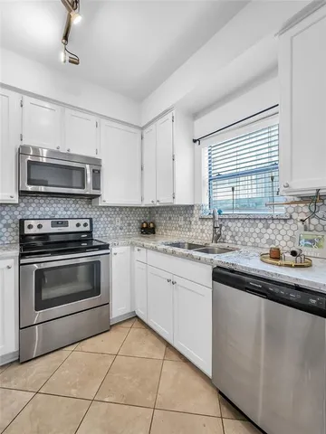 a kitchen with granite countertop a stove sink and microwave