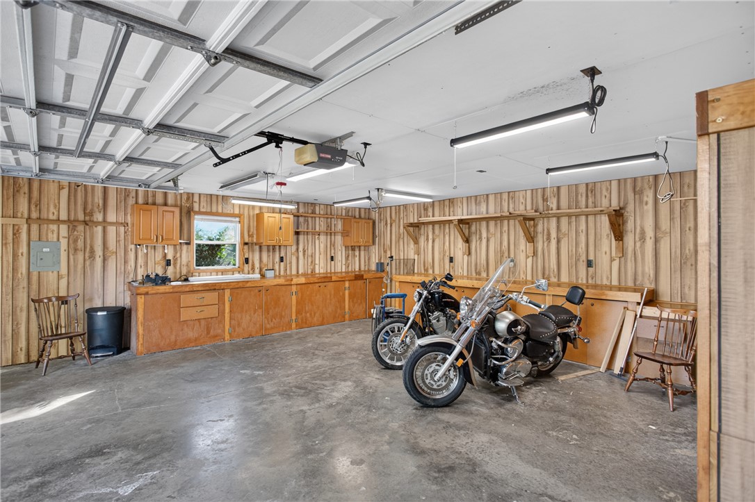 103 Dorsey Lane Walhalla, SC 29691 - Photo 29 of 42 A versatile garage featuring extensive wooden workbenches, overhead lighting, and concrete flooring.