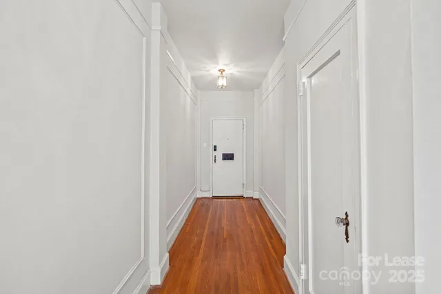 a view of a hallway with wooden floor