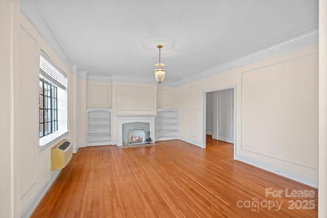 a view of empty room with wooden floor and fireplace