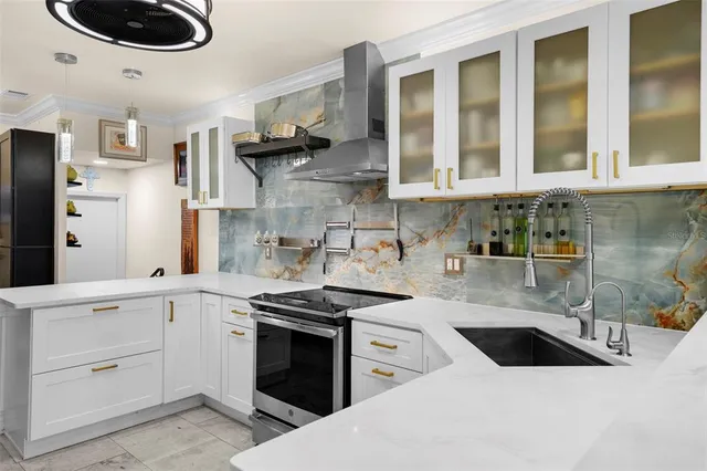 a kitchen with stainless steel appliances granite countertop a sink a stove and a refrigerator