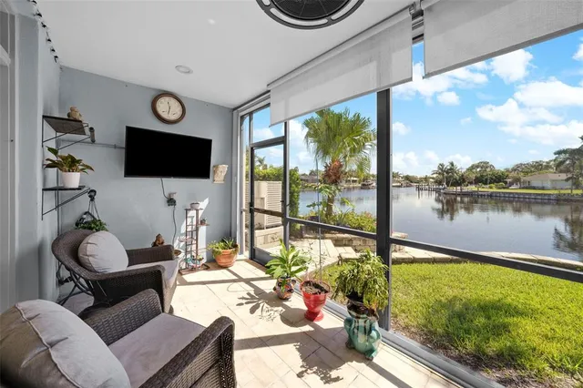 a living room with furniture a flat screen tv and a floor to ceiling window