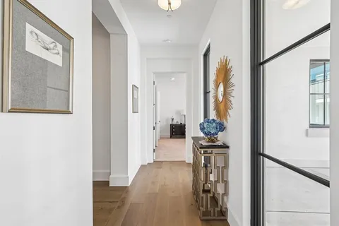 a view of a hallway with furniture and wooden floor