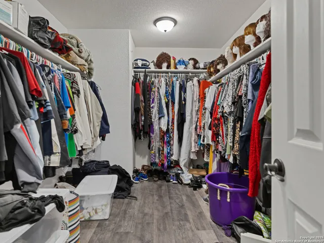 a view of walk in closet with clothes